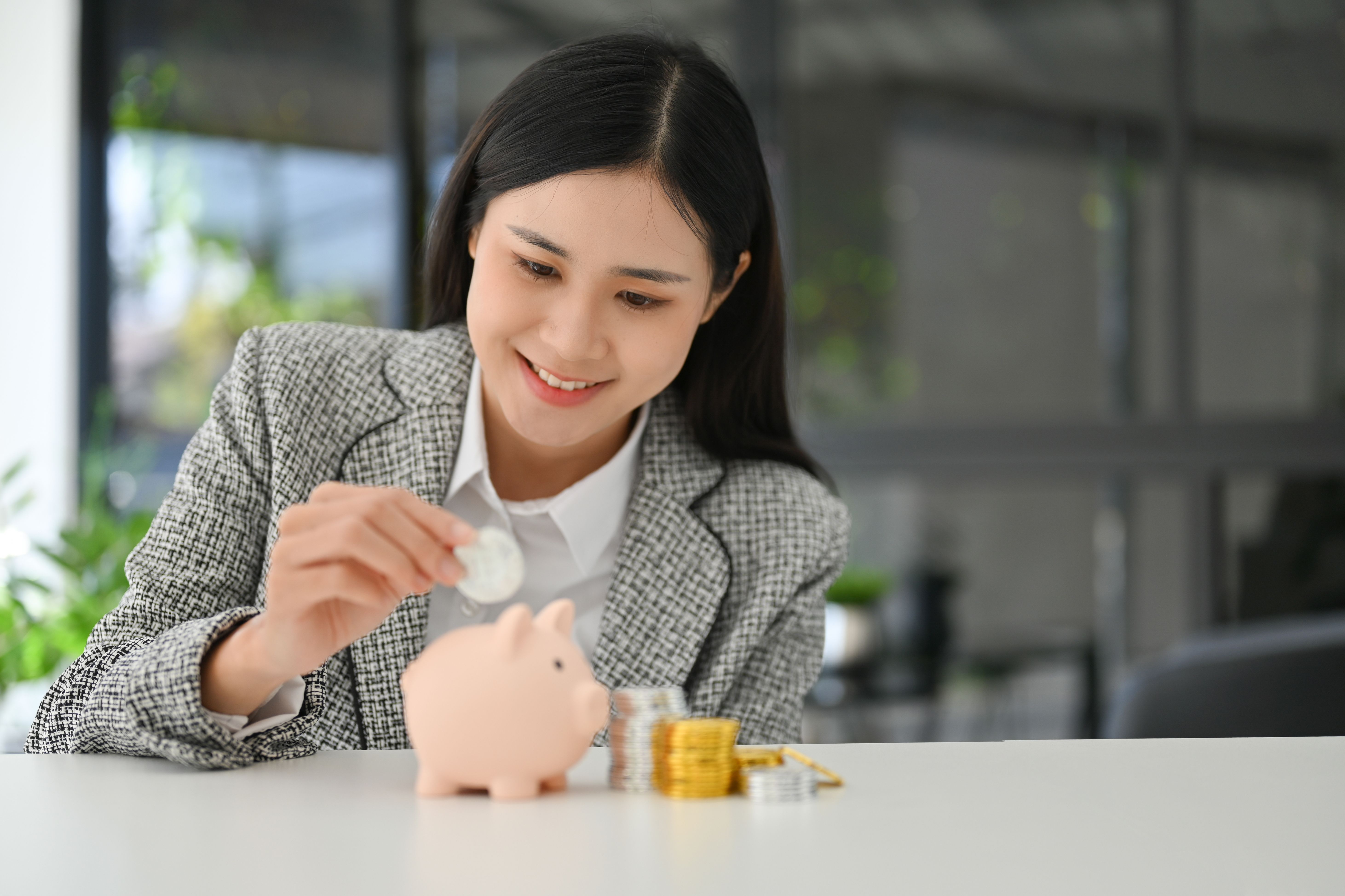 beautiful-asian-businesswoman-insert-coins-pink-piggy-bank-table.jpg